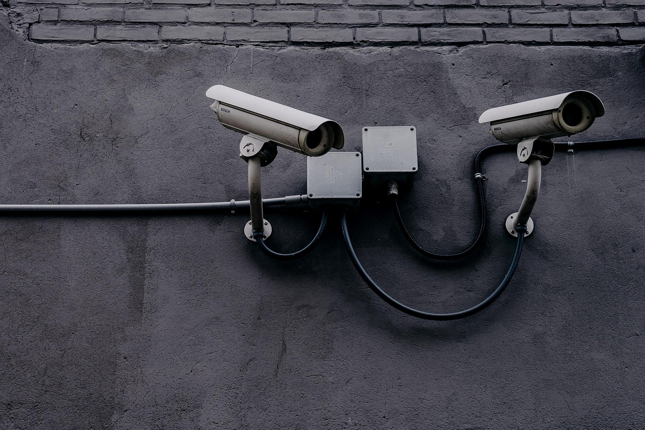 Surveillance cameras on a wall - OPSEC starts by mapping who is watching and what they can realistically collect about you.